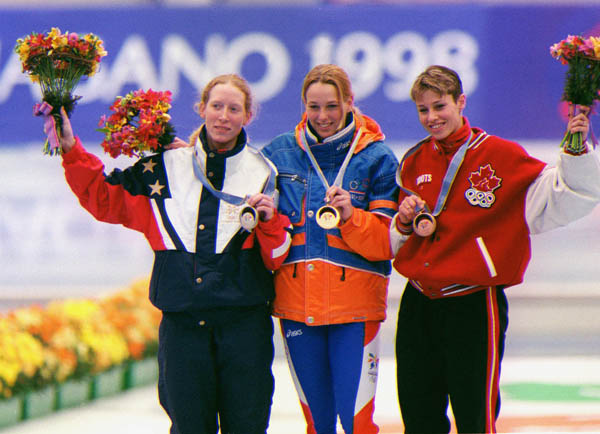 Canada's Catriona Le May Doan (R) shows off her bronze medal she won in the women's long track speed skating event at the 1998 Nagano Winter Olympics. (CP PHOTO/COA)