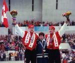 Canadians Jeremy Wotherspoon (background)  and Kevin Overland stand on the winners podium after winning bronze and silver medals in the men's long track speed skating portion of the 1998 Nagano Winter Olympics.(CP PHOTO/COA)