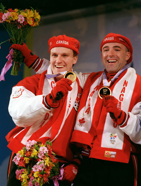 Canada's Pierre Lueders and Dave MacEachern show off the gold medals they won for the bobsleigh event at the 1998 Nagano Winter Olympics. (CP PHOTO/COA)