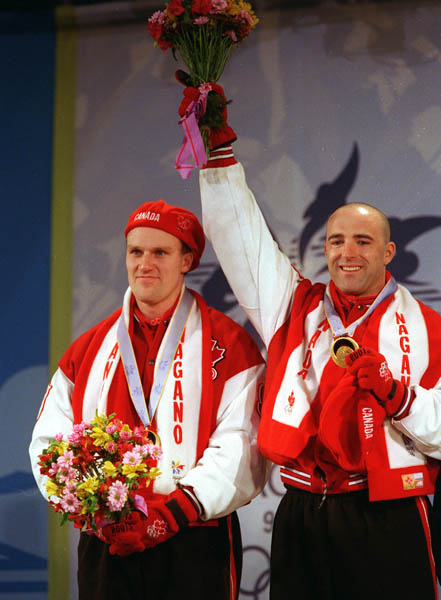 Canada's Pierre Luedes and Dave MacEachern stand n the winners podium after winning the gold medal for the bobsleigh event at the 1998 Nagano Winter Olympics. (CP PHOTO/COA)