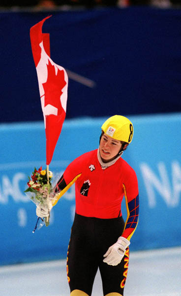 Canada's Annie Perreault carries the flag after winning the gold medal  in the women's short track speed skating event at the 1998 Nagano Winter Olympics. (CP PHOTO/COA)