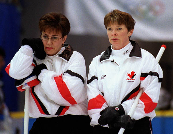 Canada's Sandra Schmirler (L) and Jan Betker watch their opponents take their turn during a curling match at the 1998 Nagano Winter Olympics. (CP PHOTO/COA)
