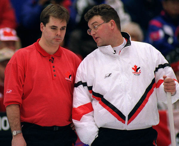 Canada's Richard Hart (L) and Mike Harris talk during a break in play at the 1998 Nagano Winter Olympics. (CP PHOTO/COA)