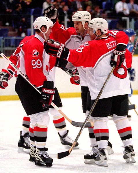 Canada's Wayne Gretzky is congratulated by team mates and  after scoring a goal for Team Canada at the 1998 Nagano Winter Olympics. (CP PHOTO/COA)