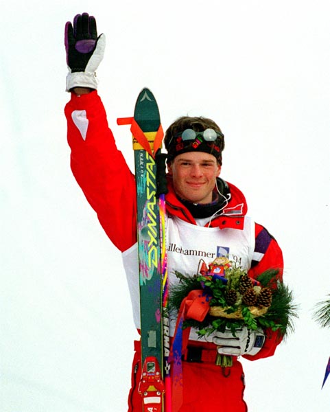 Canada's Jean-Luc Brassard waves at the crowd from the winners podium after winning the gold medal in the men's freestyle ski event at the 1994 Lillehammer Winter Olympics. (CP PHOTO/ COA)