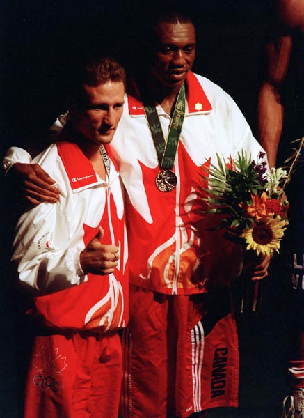 Canada's David Defiagbon (right) celebrates the silver medal he won in the boxing event at the 1996 Atlanta Summer Olympic Games. (CP PHOTO/COA/Claus Andersen)