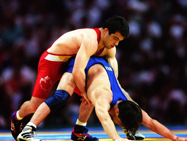 Canada's Guivi Sissaouri (top)  competing in the wrestling event against American Kendall Cross at the 1996 Atlanta Summer Olympic Games. (CP PHOTO/COA/Claus Andersen)