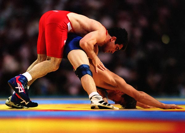 Canada's Guivi Sissaouri (top) competing against Kendall Cross in the wrestling event at the 1996 Atlanta Summer Olympic Games. (CP PHOTO/COA/Claus Andersen)