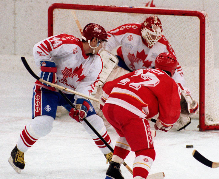 Canada's Curt Giles (left) and Sean Burke (goalie) competing in the Gold Medal game against the Unified Team in which Canada won Silver at the 1992 Albertville Olympic winter Games. (CP PHOTO/COA/Scott Grant)