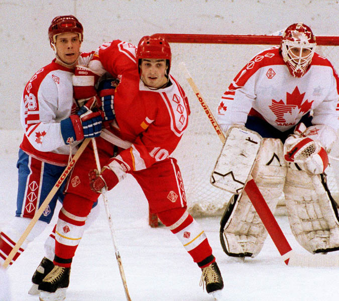 Canada's Brad Schlegel (left) and Sean Burke (goalie) competing in the Gold Medal game against the Unified Team in which Canada won Silver at the 1992 Albertville Olympic winter Games. (CP PHOTO/COA/Scott Grant)