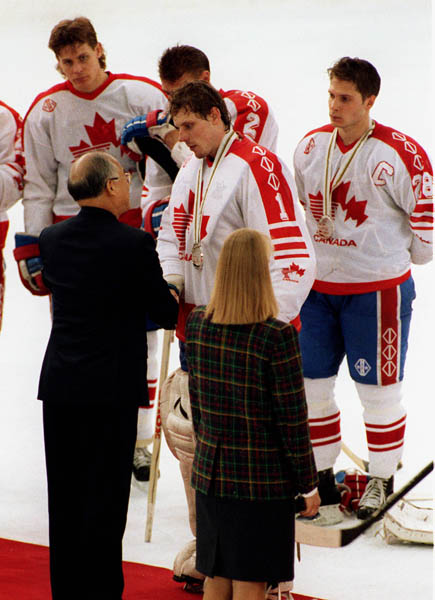 Canada's Sean Burke (centre) and behind him Brad Schlegel receiving their medals after the Gold Medal game against the Unified Team in which Canada won Silver at the 1992 Albertville Olympic winter Games. (CP PHOTO/COA/Scott Grant)