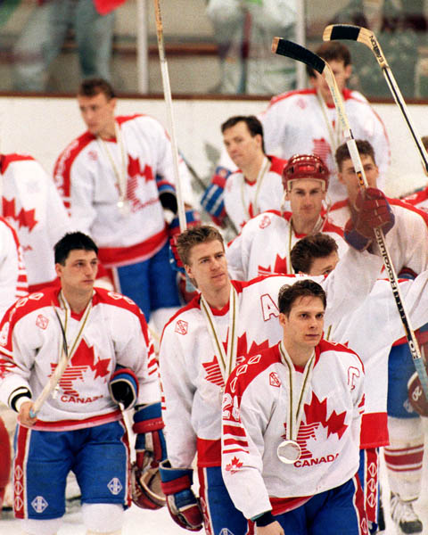 Canada's Brad Schlegel and Chris Kontos (foreground) after receiving their medals in the Gold Medal game against the Unified Team in which Canada won Silver at the 1992 Albertville Olympic winter Games. (CP PHOTO/COA/Scott Grant)
