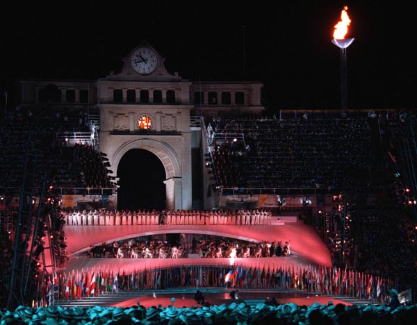 Participants perform during the opening ceremonies while the Olympic Flame burns in the background at the 1992 Olympic games in Barcelona. (CP PHOTO/ COA/ Claus Andersen)