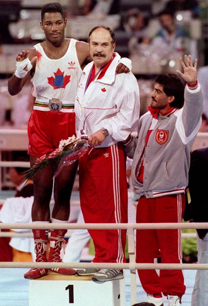 Canada's Lennox lewis celebrates his gold medal win in the boxing event with his coaches Adrian Teodorescu (centre) and Asif Dar (right) at the 1988 Olympic games in Seoul. (CP PHOTO/ COA/ S.Grant)