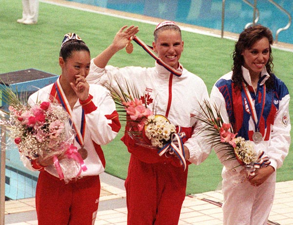 Canada's Carolyn Waldo celebrates her gold medal win in the synchronized swimming event along with silver medalist Tracie Ruiz-Conforto of the USA and bronze medalist Mikako Kotani of Japan at the 1988 Olympic games in Seoul. (CP PHOTO/ COA/ Ted Grant)