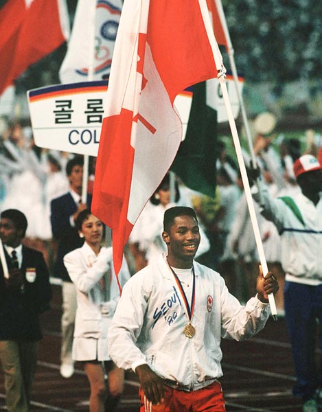 Canada's Lennox Lewis carries the Canadian flag during the closing ceremonies at the 1988 Olympic games in Seoul. (CP PHOTO/ COA/ Cromby McNeil)