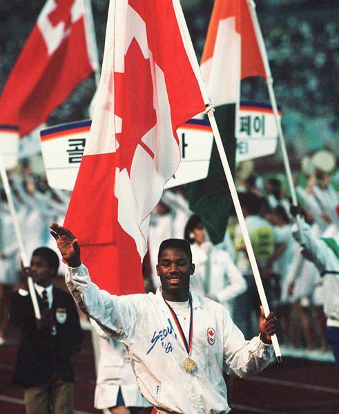 Canada's Lennox Lewis carries the Canadian flag during the closing ceremonies at the 1988 Olympic games in Seoul. (CP PHOTO/ COA/ Cromby McNeil)