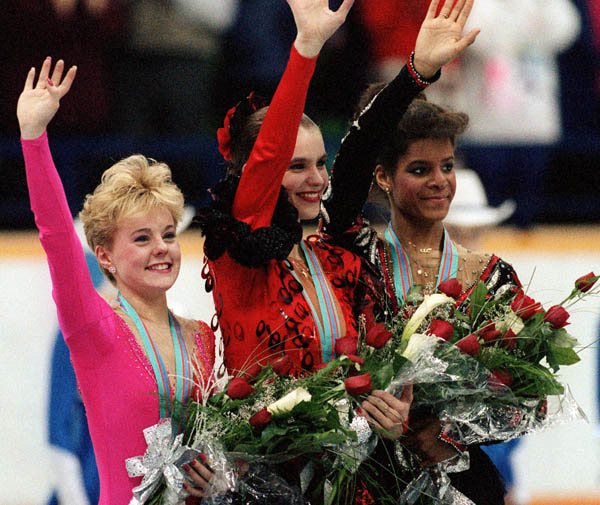 Canada's Elizabeth Manley (left) celebrates her silver medal win in the figure skating event along with gold medalist Katarina Witt (centre) of East Germany and Bronze medalist Debi Thomas of the U.S.A. at the 1988 Winter Olympics in Calgary. (CP PHOTO/CO