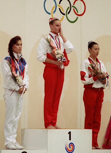 Canada's Carolyn Waldo celebrates her gold medal win in the synchronized swimming event along  with silver medal winner Tracie Ruiz-Conforto (left) of the United States and bronze medal winner Mickako Kotani of Japan (right) at the 1988 Olympic games in S