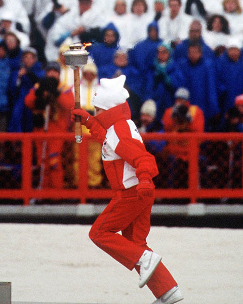A toarch bearer carries the flame during opening ceremonies of the 1988 Winter Olympics in Calgary. (CP PHOTO/COA/T. O'lett)