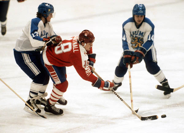 Canada's Russ Courtnall (centre) is checked during hockey action against Finland at the 1984 Winter Olympics in Sarajevo. (CP PHOTO/ COA/J. Merrithew)
