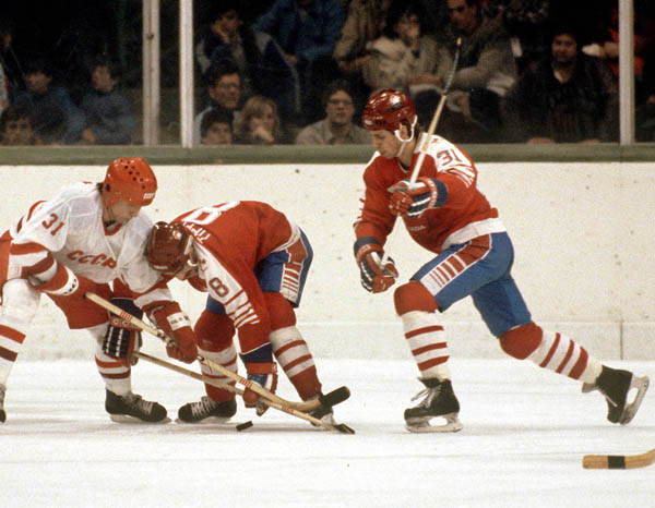 Canada's Dave Tippett reaches for the puck as teammate Vaughn Karpan (right) comes in to help during hockey action against the USSR at the 1984 Winter Olympics in Sarajevo. (CP PHOTO/ COA/O. Bierwagon)