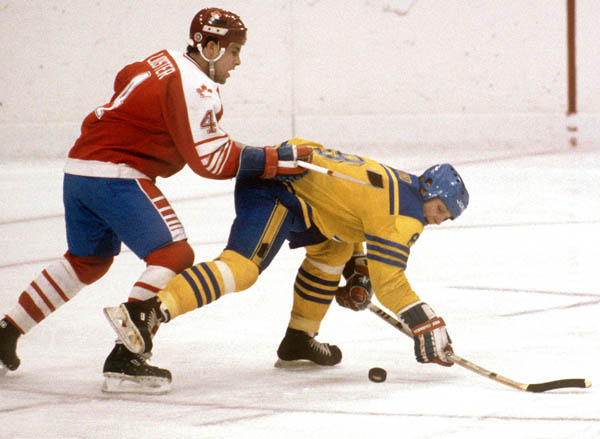 Canada's Doug Lidster (left) checks a Team Sweden player during hockey action at the 1984 Winter Olympics in Sarajevo. (CP PHOTO/ COA/O. Bierwagon )