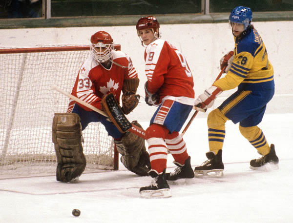 Canada's James Patrick (#9) and Mario Gosselin (goalie) look towards the puck during hockey action  against Sweden at the 1984 Winter Olympics in Sarajevo. (CP PHOTO/ COA/O. Bierwagon )