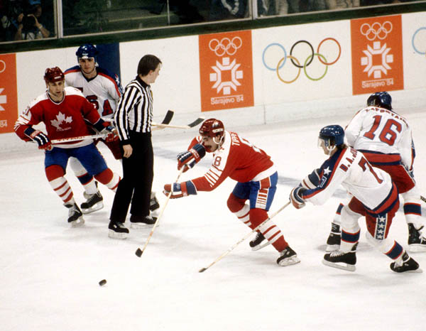 Canada's Vaughn Karpan (left) and Dave Tippett (centre) compete in hockey action against the United States at the 1984 Winter Olympics in Sarajevo. (CP PHOTO/ COA/O. Bierwagon )