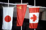The Canadian flag is raised, along with flags from Japan and the USSR, during the medal ceremony for Gaetan Boucher in honor of his bronze medal win in a speed skating event at the 1984 Winter Olympics in Sarajevo. (CP Photo/COA/ O. Bierwagon)