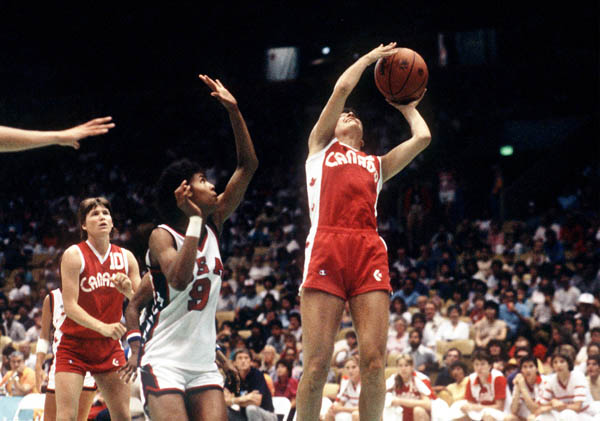 Canada's Debbie Huband (right) leaps to throw during women's basketball action at the 1984 Olympic Games in Los Angeles. (CP Photo/ COA/Tim O'lett)