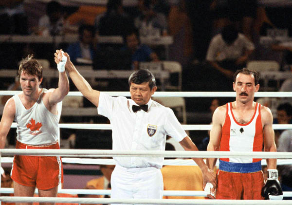 Canada's Shawn O'Sullivan (left) is declared the winner in a boxing match at the 1984 Olympic games in Los Angeles. (CP PHOTO/ COA/ Tim O'lett)