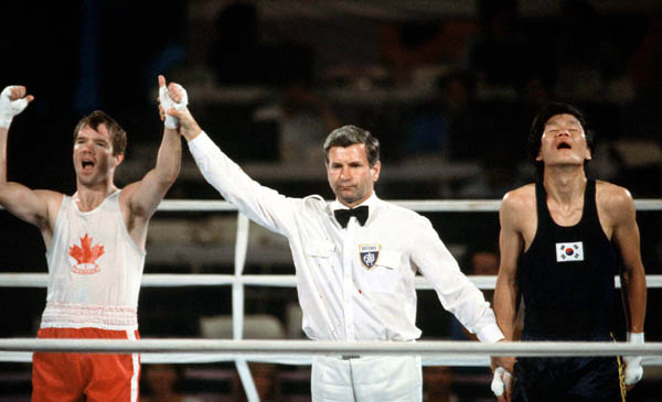 Canada's Shawn O'Sullivan (left) is declared the winner of a boxing match at the 1984 Olympic games in Los Angeles. (CP PHOTO/ COA/ Tim O'lett)