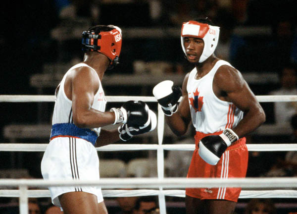 Canada's Lennox Lewis (right) competes in the boxing event at the 1984 Olympic games in Los Angeles. (CP PHOTO/ COA/ Tim O'lett)