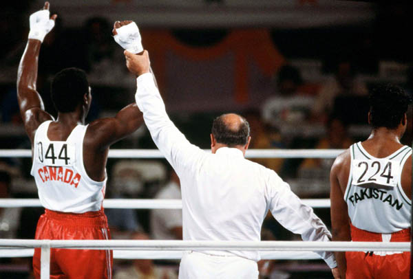 Canada's Lennox Lewis (left) is declared the winner of a match in the boxing event at the 1984 Olympic games in Los Angeles. (CP PHOTO/ COA/ Tim O'lett)