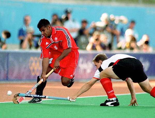 Canada's Alan Brahmst (left) goes around a defender during field hockey action at the 2000 Sydney Olympic Games. (CP Photo/ COA)