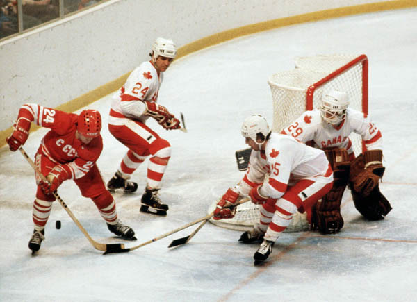 Canada's Terry O'Malley (24), John Devaney (15) and Paul Pageau (goalie) compete in hockey action against the U.S.S.R. at the 1980 Winter Olympics in Lake Placid. (CP Photo/ COA)