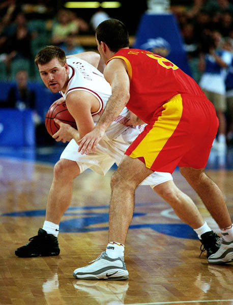 Canada's David Daniels (left) looks for a pass receiver during basketball action at the 2000 Sydney Olympic Games. (CP Photo/ COA)