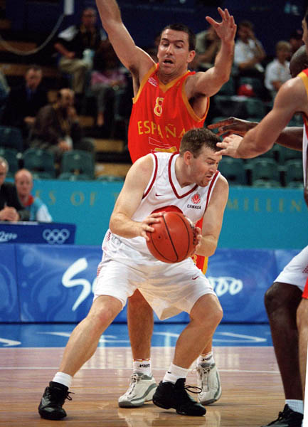 Canada's David Daniels (front) goes around a Spanish opponent during basketball action at the 2000 Sydney Olympic Games. (CP Photo/ COA)