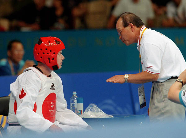 Dominique Bosshart du Canada ( gauche) assiste par l'entraneur Joo Won Kang participe  une preuve de taekwondo aux Jeux olympiques de Sydney de 2000. (Photo PC/AOC)