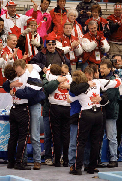 Canada's women's curling team are congratulated by their husbands after winning the gold medal at the 1998 Nagano Winter Olympics. (CP PHOTO/COA/Mike Ridewood)
