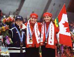 Canada's Catriona Le May Doan (centre) and Susan Auch (right) celebrate their respective gold and silver medals at a long track speed skating event at the 1998 Nagano Winter Olympics. (CP PHOTO/COA/Mike Ridewood)
