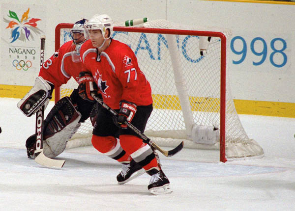 Canada's Patrick Roy (goalie) and Ray Bourque (77) participate in hockey action against the United States at the 1998 Winter Olympics in Nagano. (CP Photo/COA/ F. Scott Grant )