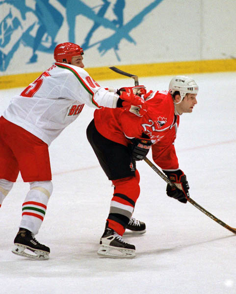 Canada's Shayne Corson (right) receives a cross-check from a Belarus player during hockey action at the 1998 Winter Olympics in Nagano. (CP Photo/COA/ F. Scott Grant )