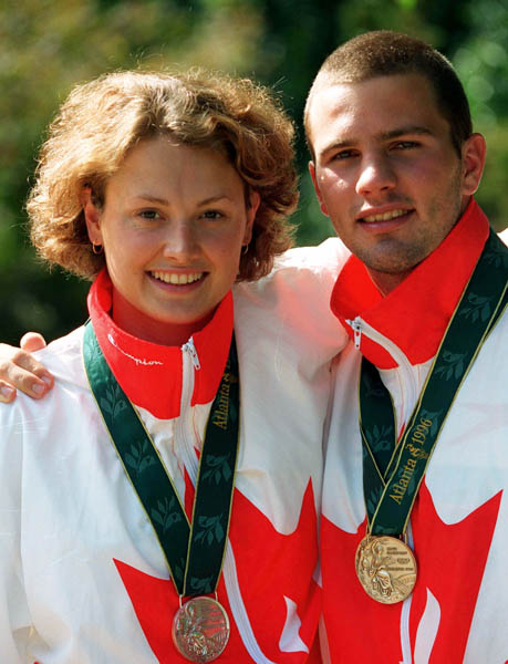 Canada's Marianne Limpert and Curtis Myden celebrate after winning respectively a silver and two gold medals in the swimming event at the 1996 Atlanta Olympic Games. (CP Photo/ COA/Mike RIdewood)