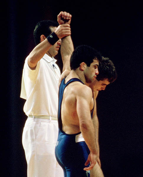 Canada's Guivi Sissaouri (blue) is declared a winner of a wrestling match at the 1996 Atlanta Olympic Games. (CP Photo/COA/Mike Ridewood)
