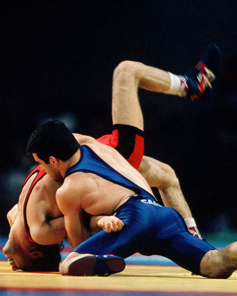 Canada's Guivi Sissaouri (blue) competes in the wrestling event at the 1996 Atlanta Olympic Games. (CP Photo/COA/Mike Ridewood)
