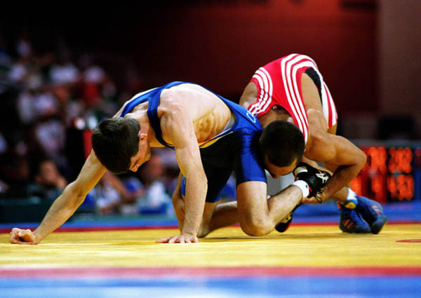 Canada's Greg Woodcroft (blue) competes in the wrestling event at the 1996 Atlanta Olympic Games. (CP Photo/COA/Mike Ridewood)
