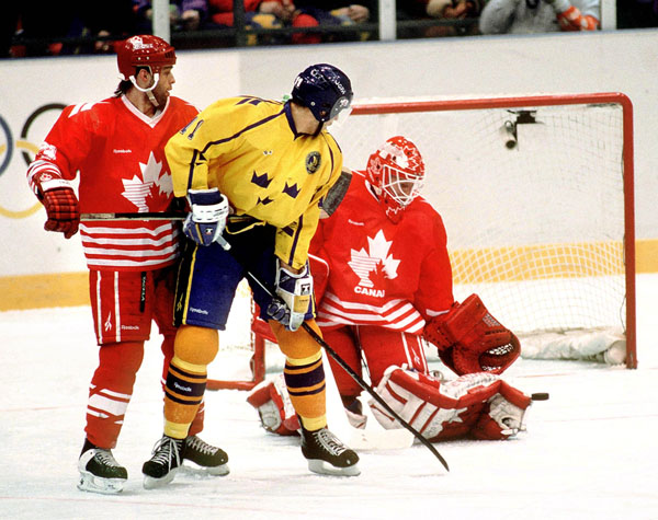 Canada's Mark Astley (left) and Corey Hirsch (goalie) cmpete in hockey action at the 1994 Winter Olympics in Lillehammer. (CP Photo/COA/Claus Andersen)