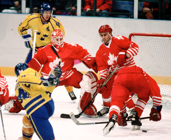 Canada's Corey Hirsch (goalie) and Dwayne Norris compete in hockey action against Sweden at the 1994 Winter Olympics in Lillehammer. (CP Photo/COA/Claus Andersen)